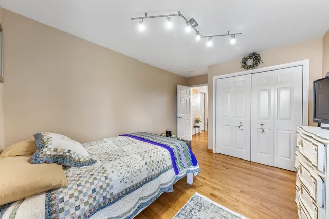 a bedroom with a bed and wooden floor