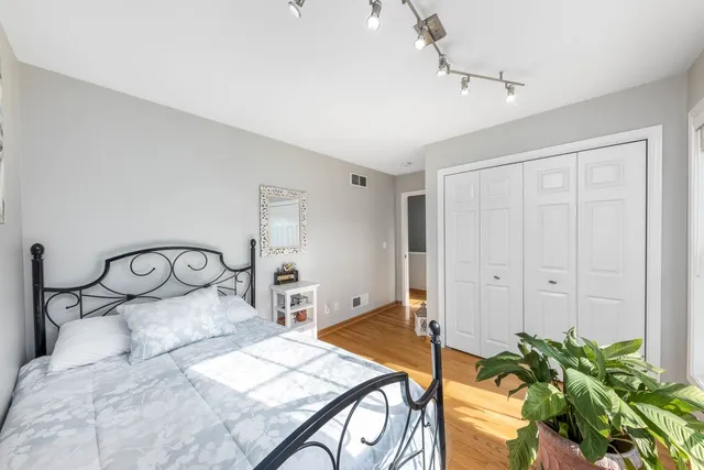 a bedroom with a bed chandelier and a window