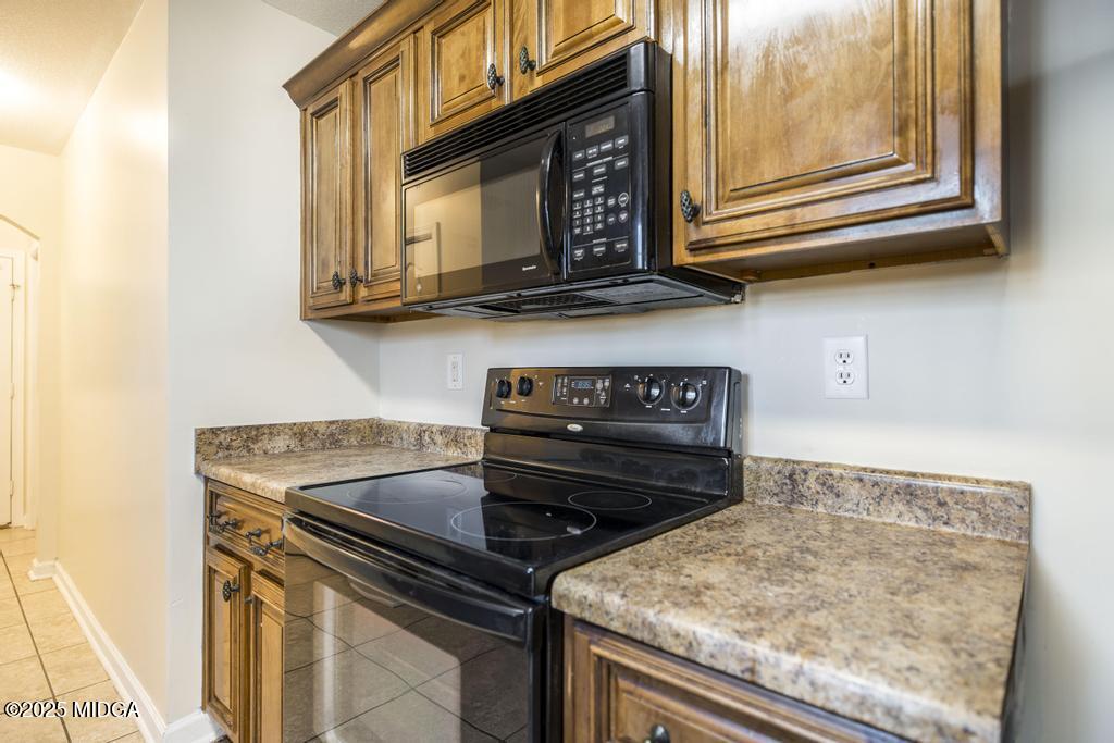 204 Chimney Rock Road Perry, GA 31069 - Photo 11 of 28 a kitchen with stainless steel appliances granite countertop a stove microwave and sink
