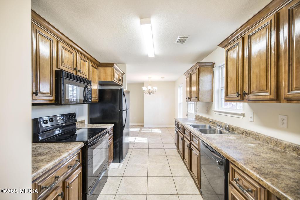 204 Chimney Rock Road Perry, GA 31069 - Photo 13 of 28 a large kitchen with stainless steel appliances granite countertop a stove top oven a refrigerator a sink and dishwasher