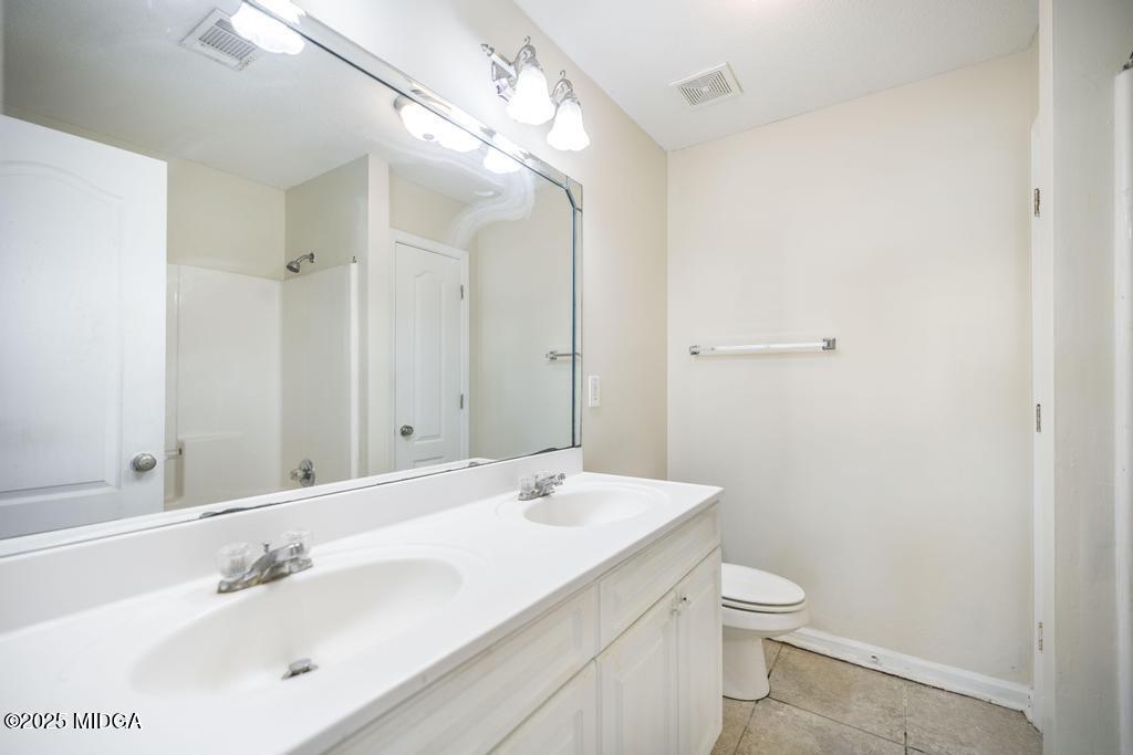 204 Chimney Rock Road Perry, GA 31069 - Photo 17 of 28 a bathroom with a toilet a sink and mirror