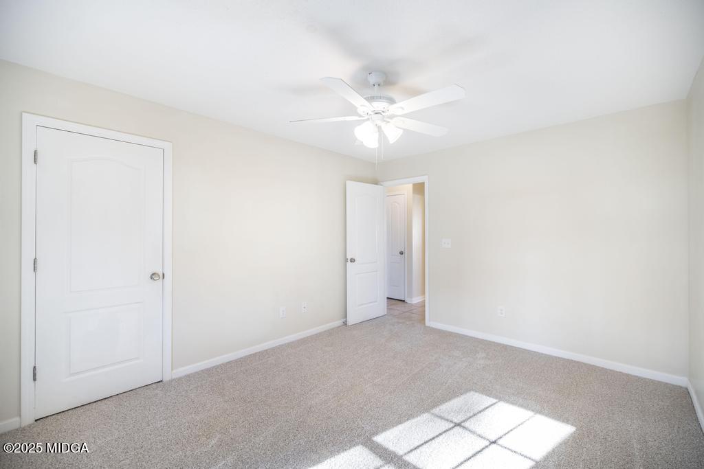 204 Chimney Rock Road Perry, GA 31069 - Photo 21 of 28 an empty room with a ceiling fan and a window