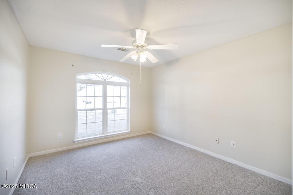 204 Chimney Rock Road Perry, GA 31069 - Photo 23 of 28 an empty room with windows and ceiling fan