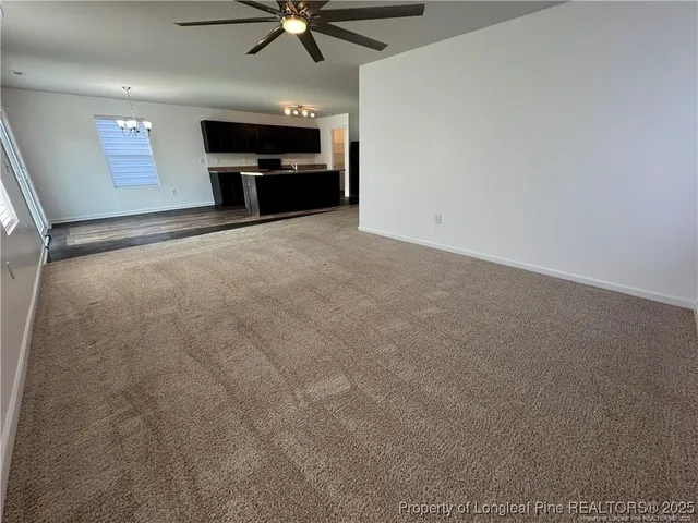 an empty room with windows and fireplace