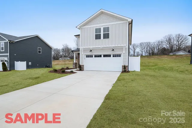 a view of a white house next to a yard and large trees