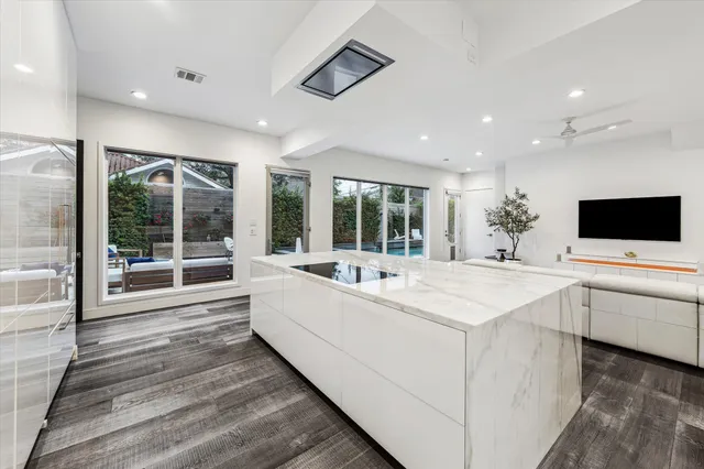 a large white kitchen with a large window