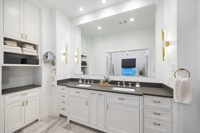 a spacious bathroom with double sink and a mirror