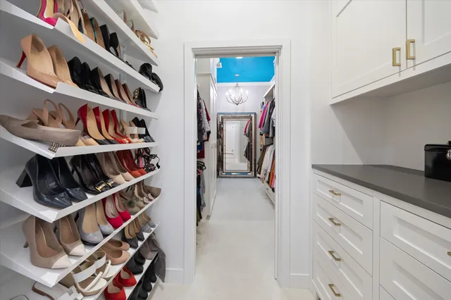 a view of walk in closet with clothes and shoes