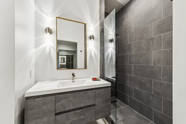 a bathroom with a sink mirror and a shower