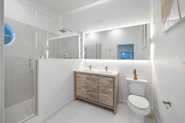 a bathroom with a granite countertop toilet sink and mirror