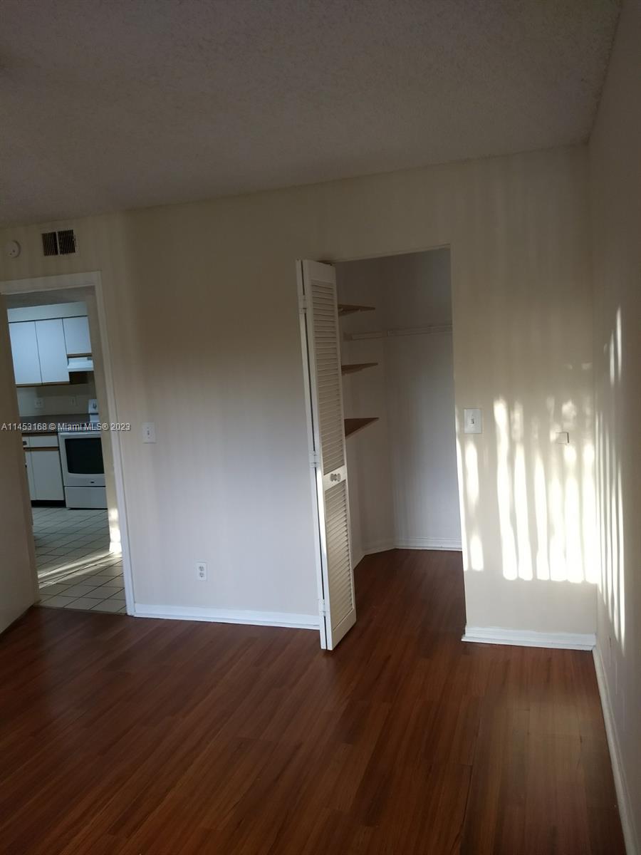 4055 West McNab Road, Unit H303 Pompano Beach, FL 33069 - Photo 6 of 29 an empty room with wooden floor staircase and windows