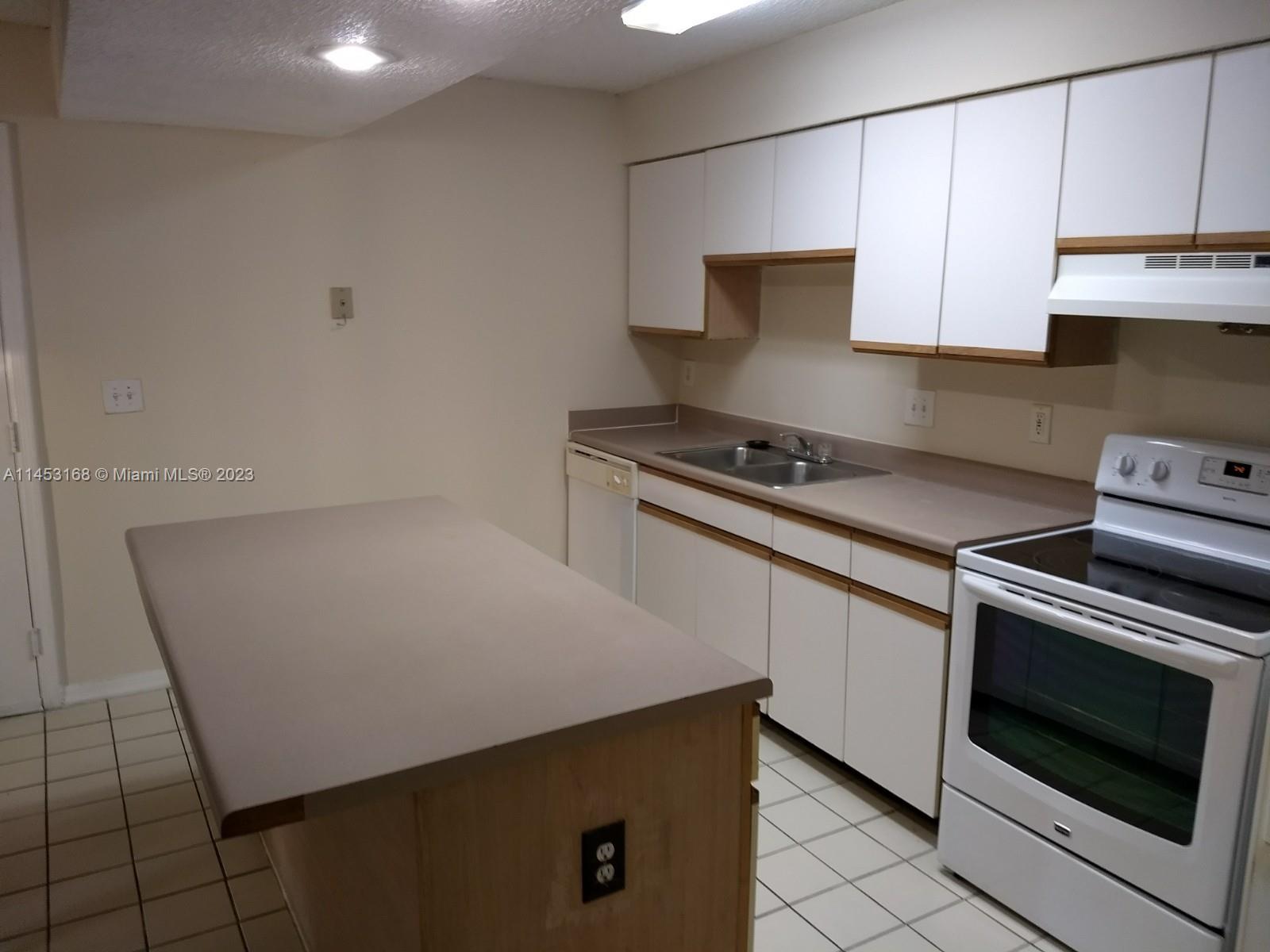 4055 West McNab Road, Unit H303 Pompano Beach, FL 33069 - Photo 7 of 29 a kitchen with cabinets and appliances