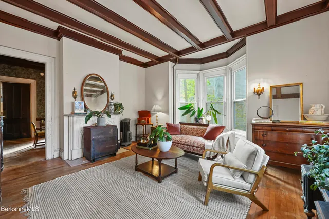 a living room with furniture a fireplace and a large window