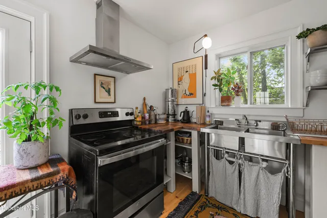 a kitchen with stainless steel appliances a stove a sink and a window