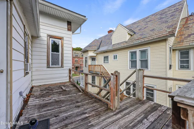 a view of a house with wooden deck front of house