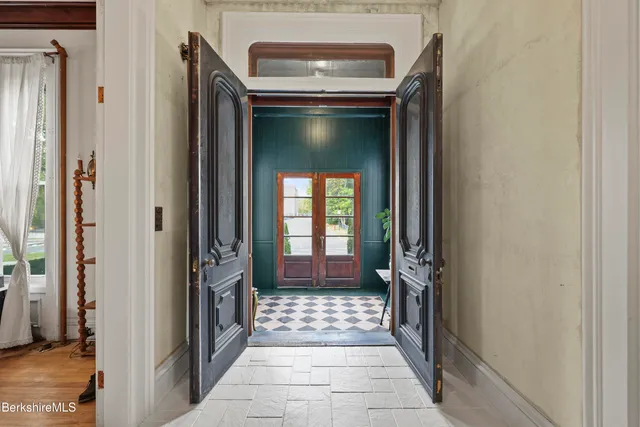 a hallway with a door and a mirror