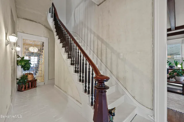 a view of staircase with lots of frames on wall and windows