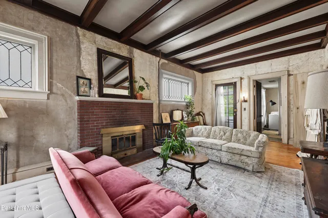 a living room with furniture a fireplace and a large window