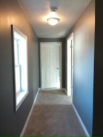 a view of hallway with windows and chandelier