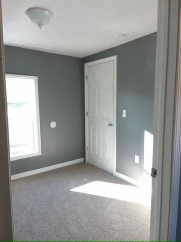 an empty room with windows and closet