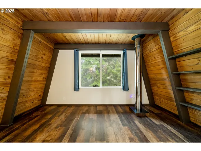 a view of hallway with a large window and wooden floor