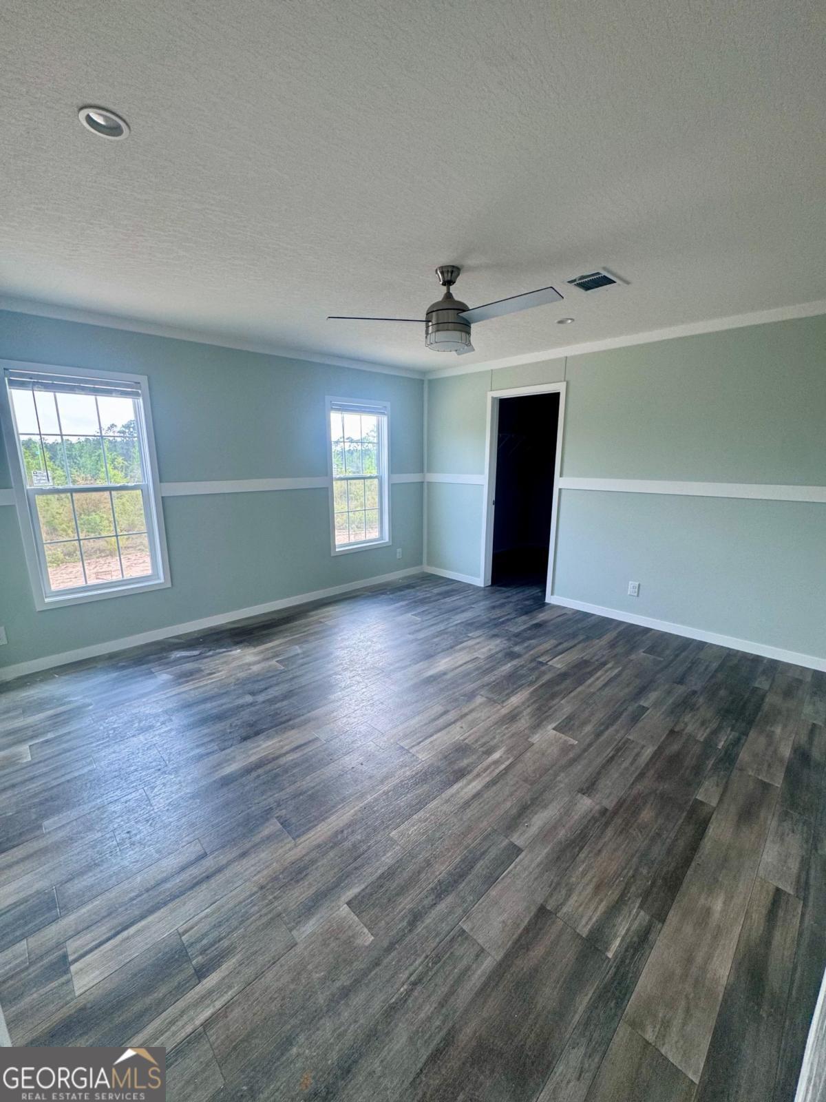 59 Long Leaf Road Hazlehurst, GA 31539 - Photo 11 of 19 an empty room with wooden floor and windows