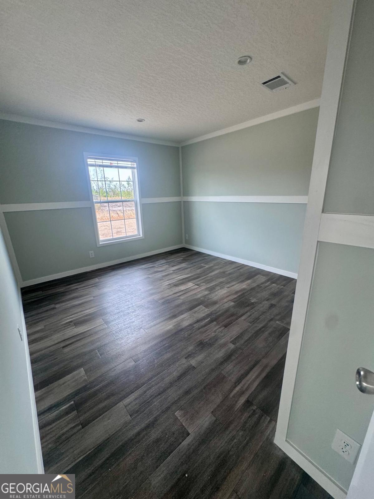 59 Long Leaf Road Hazlehurst, GA 31539 - Photo 16 of 19 a view of an empty room with a window and wooden floor