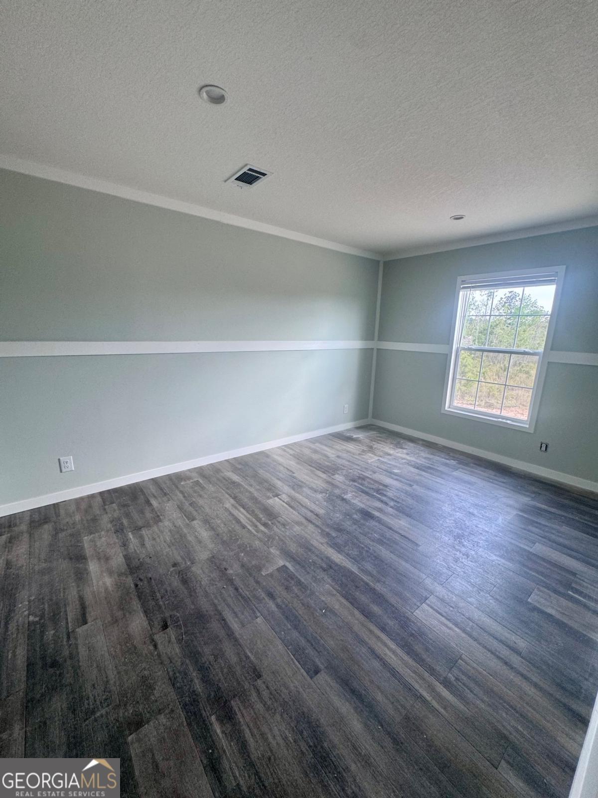 59 Long Leaf Road Hazlehurst, GA 31539 - Photo 18 of 19 a view of empty room with wooden floor and fan