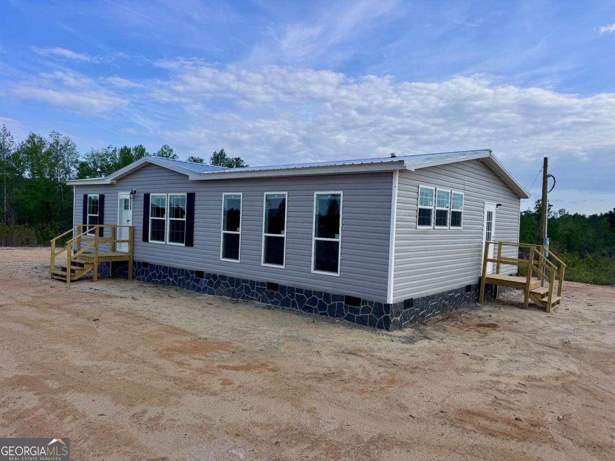 59 Long Leaf Road Hazlehurst, GA 31539 - Photo 19 of 19 a view of a house with a yard and wooden fence