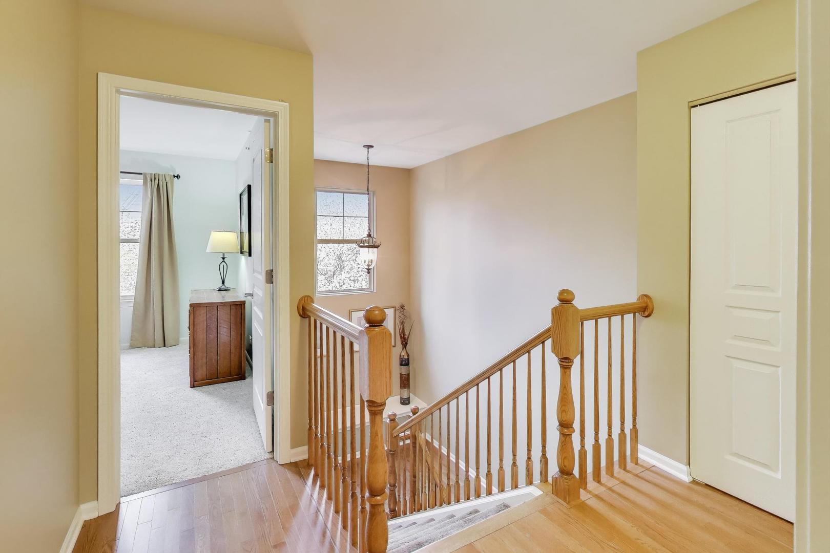 934 Tuscany Drive Streamwood, IL 60107 - Photo 18 of 45 a view of a hallway with wooden floor and staircase