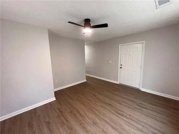 a view of an empty room with wooden floor