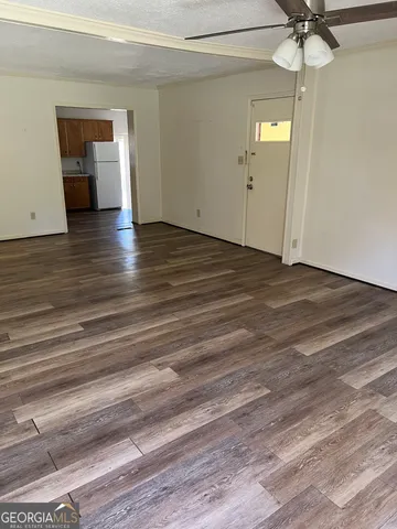a view of a livingroom with wooden floor and a ceiling fan