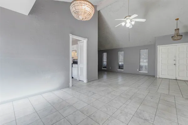 an empty room with chandelier fan