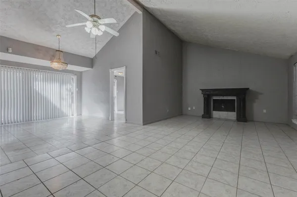 an empty room with fireplace and fan