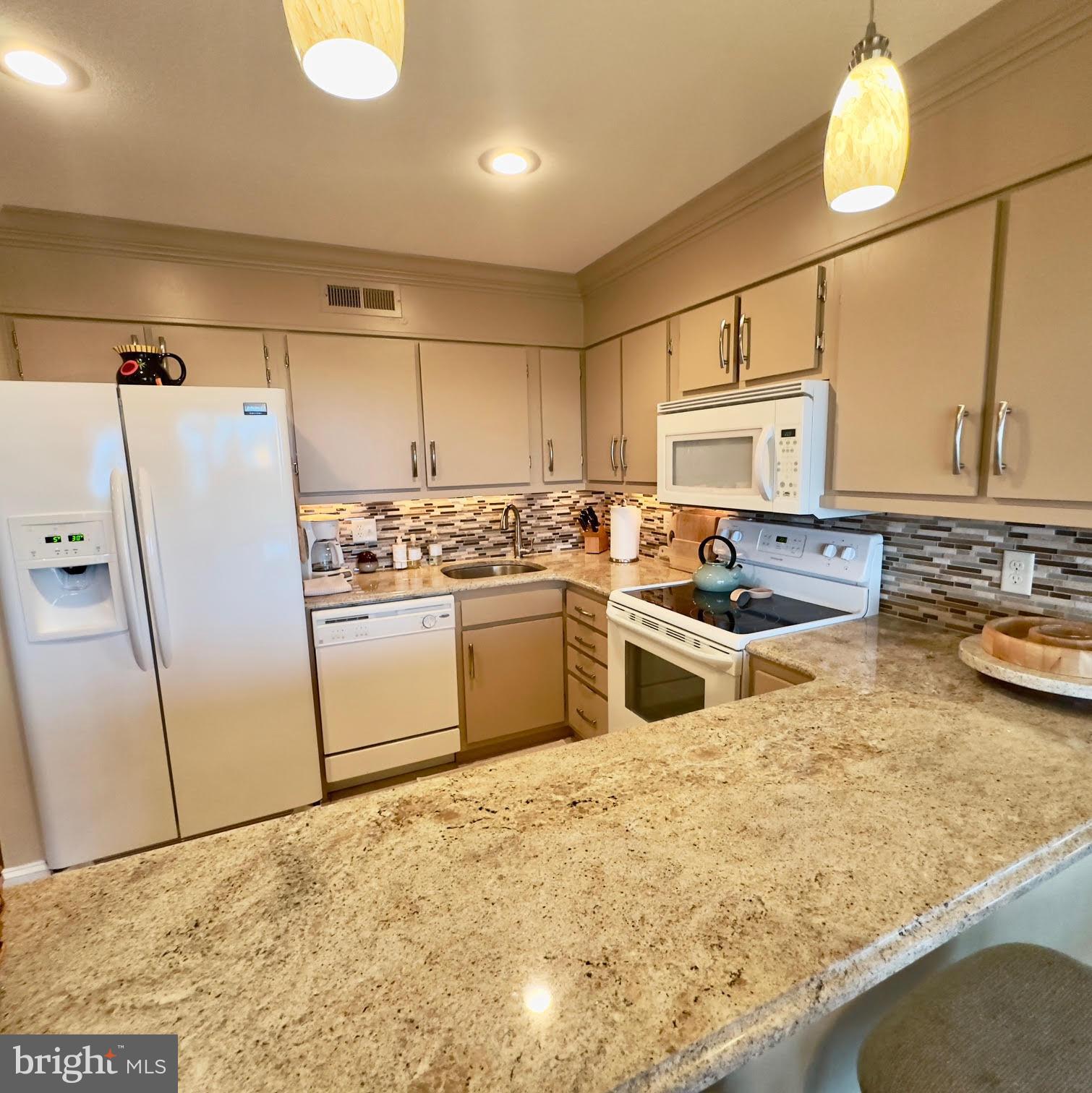 119 Old Landing Road, Unit E203 Ocean City, MD 21842 - Photo 12 of 45 a kitchen with stainless steel appliances granite countertop a sink a stove a refrigerator and white cabinets