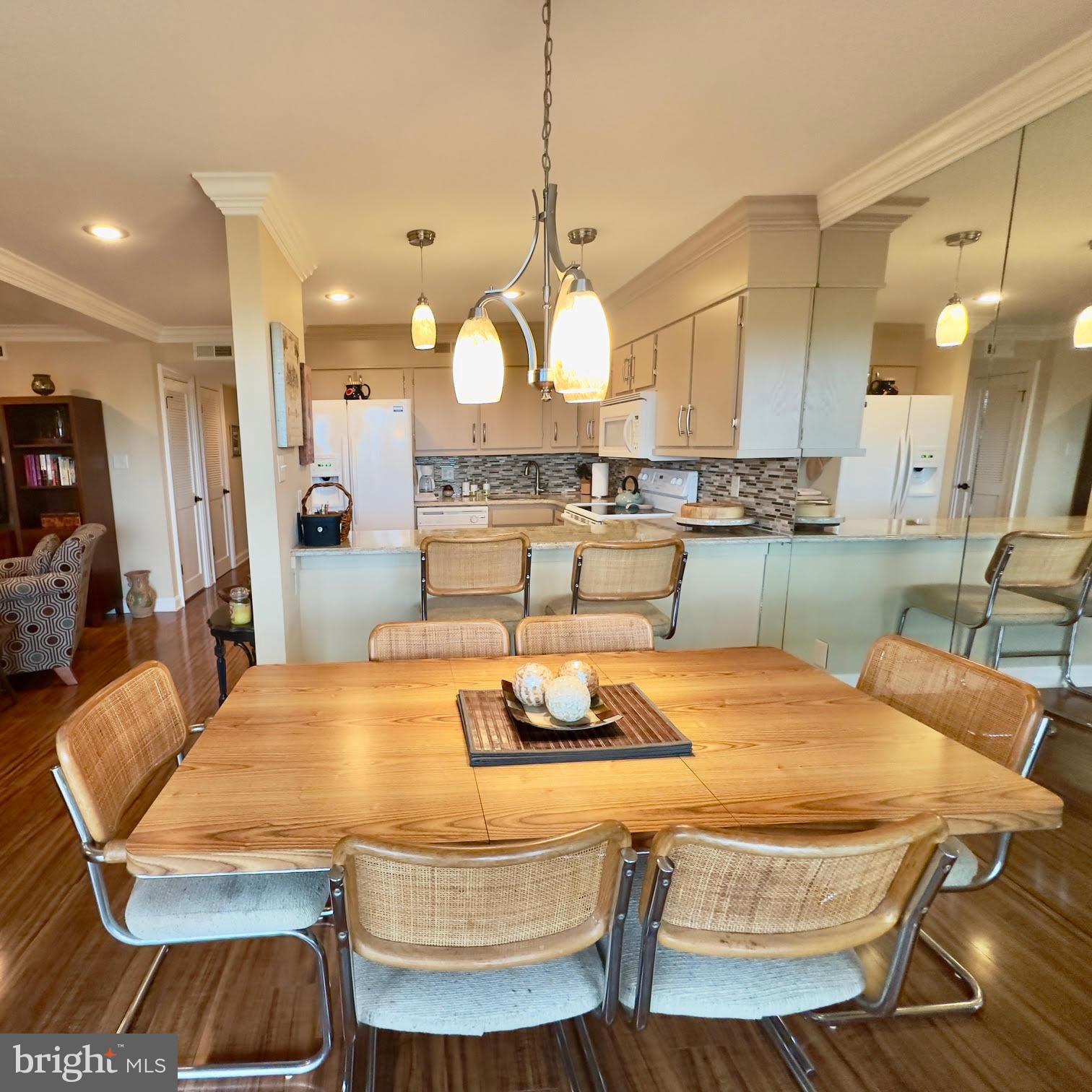 119 Old Landing Road, Unit E203 Ocean City, MD 21842 - Photo 15 of 45 a kitchen with kitchen island a dining table and chairs