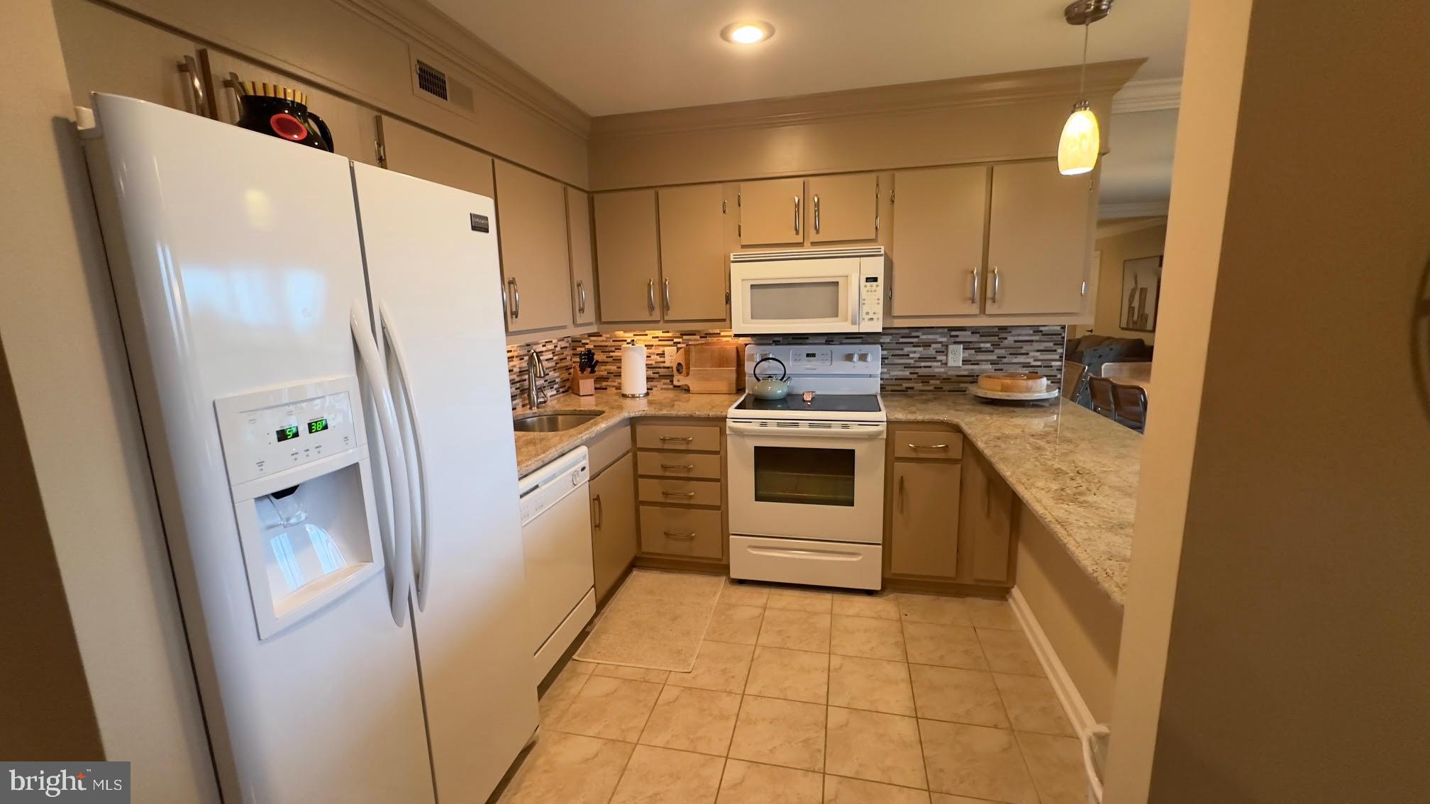 119 Old Landing Road, Unit E203 Ocean City, MD 21842 - Photo 16 of 45 a kitchen with a stove a refrigerator and a sink
