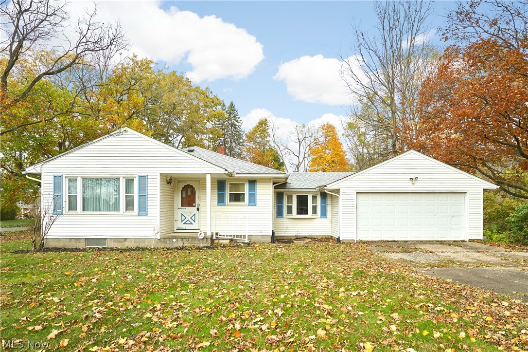 2941 Sweitzer Road Uniontown, OH 44685 - Photo 1 of 16 View of front of property with driveway, a garage, a front lawn, and a shingled roof
