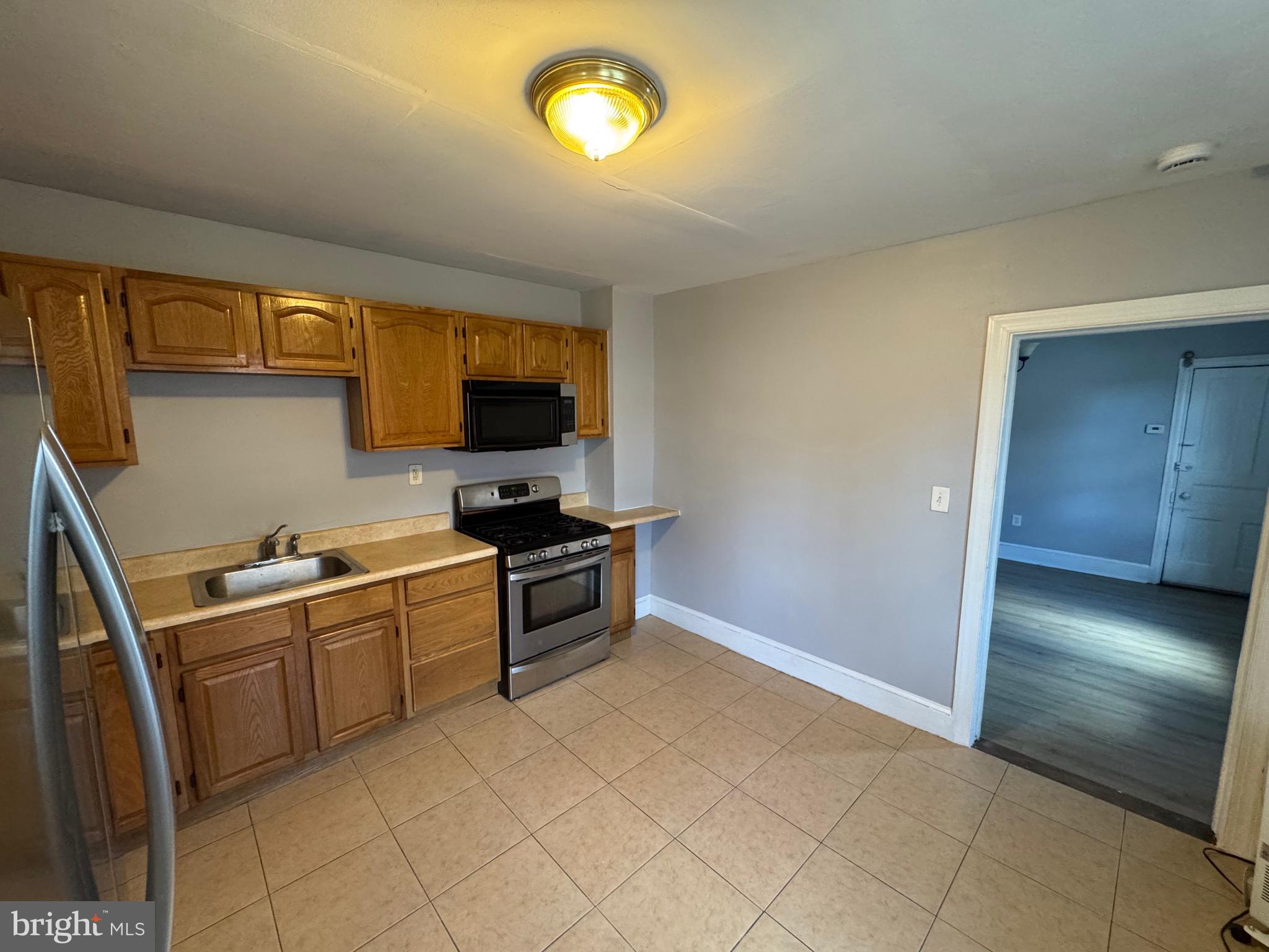 729 East Haverford Road Bryn Mawr, PA 19010 - Photo 5 of 15 a kitchen with granite countertop a sink a stove top oven and cabinetry