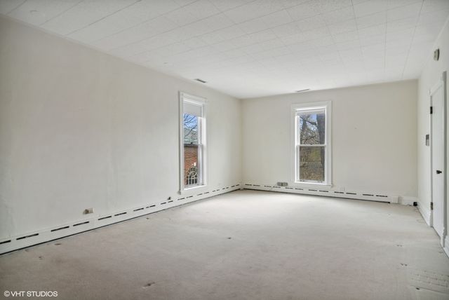 a bedroom with a bed a table and painting on the wall