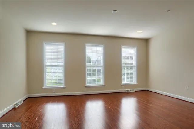 a view of room with wooden floor and windows