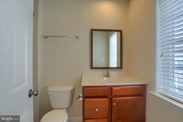 a bathroom with a toilet sink vanity and mirror