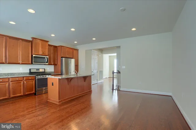 a kitchen with stainless steel appliances granite countertop a refrigerator stove top oven and sink