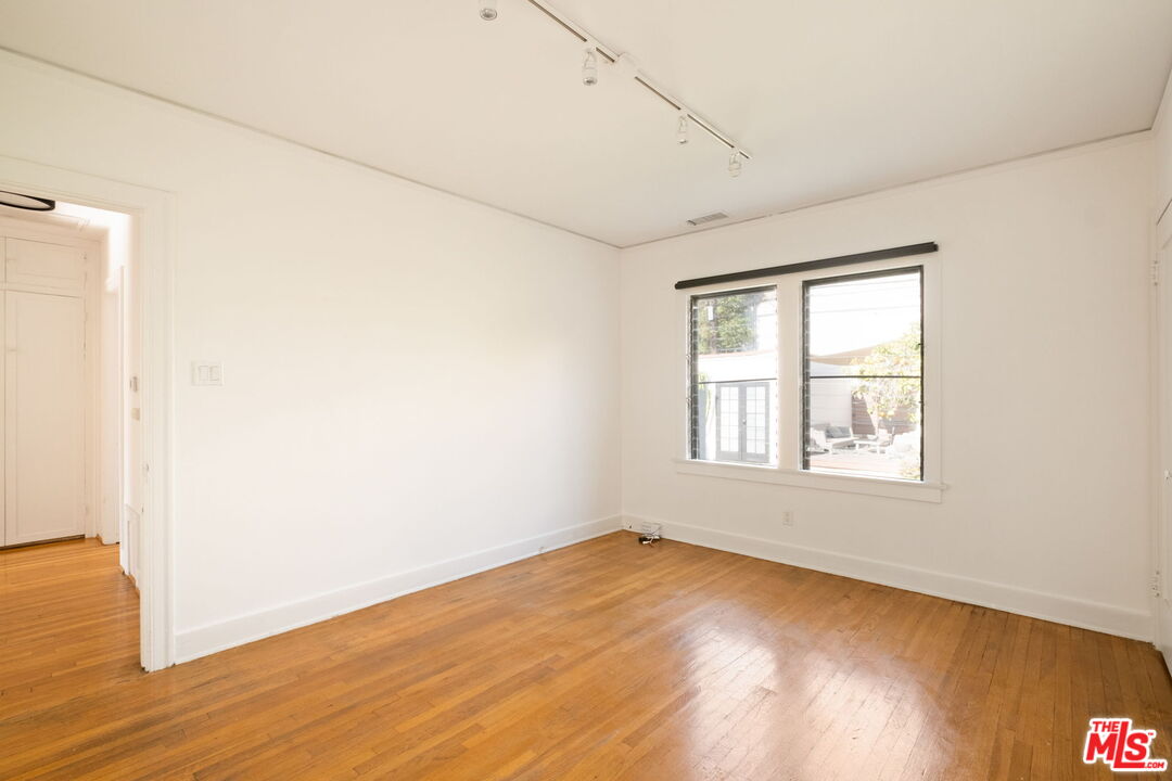813 North Orange Grove Avenue Los Angeles, CA 90046 - Photo 22 of 42 an empty room with wooden floor and windows