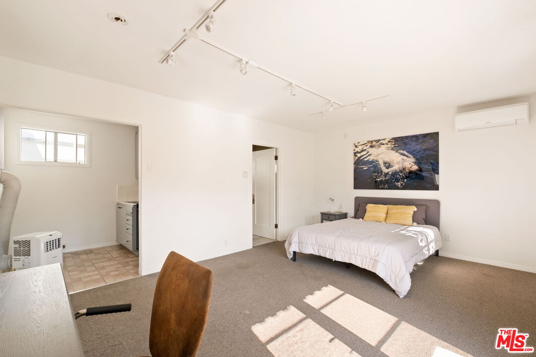 813 North Orange Grove Avenue Los Angeles, CA 90046 - Photo 24 of 42 a bedroom with a bed and wooden floor