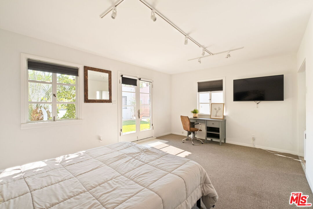 813 North Orange Grove Avenue Los Angeles, CA 90046 - Photo 25 of 42 a bedroom with a bed and a flat screen tv