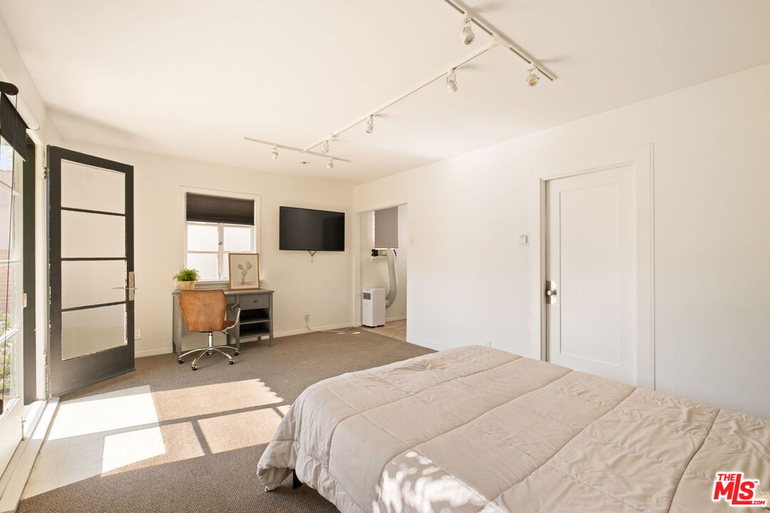 813 North Orange Grove Avenue Los Angeles, CA 90046 - Photo 26 of 42 a spacious bedroom with a bed and a view of kitchen