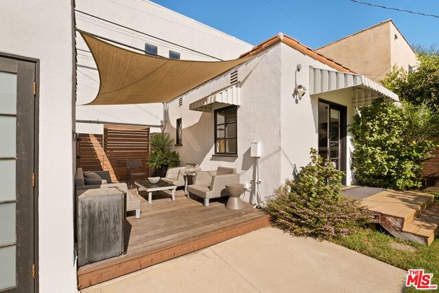 a view of a patio with couches table and chairs and potted plants