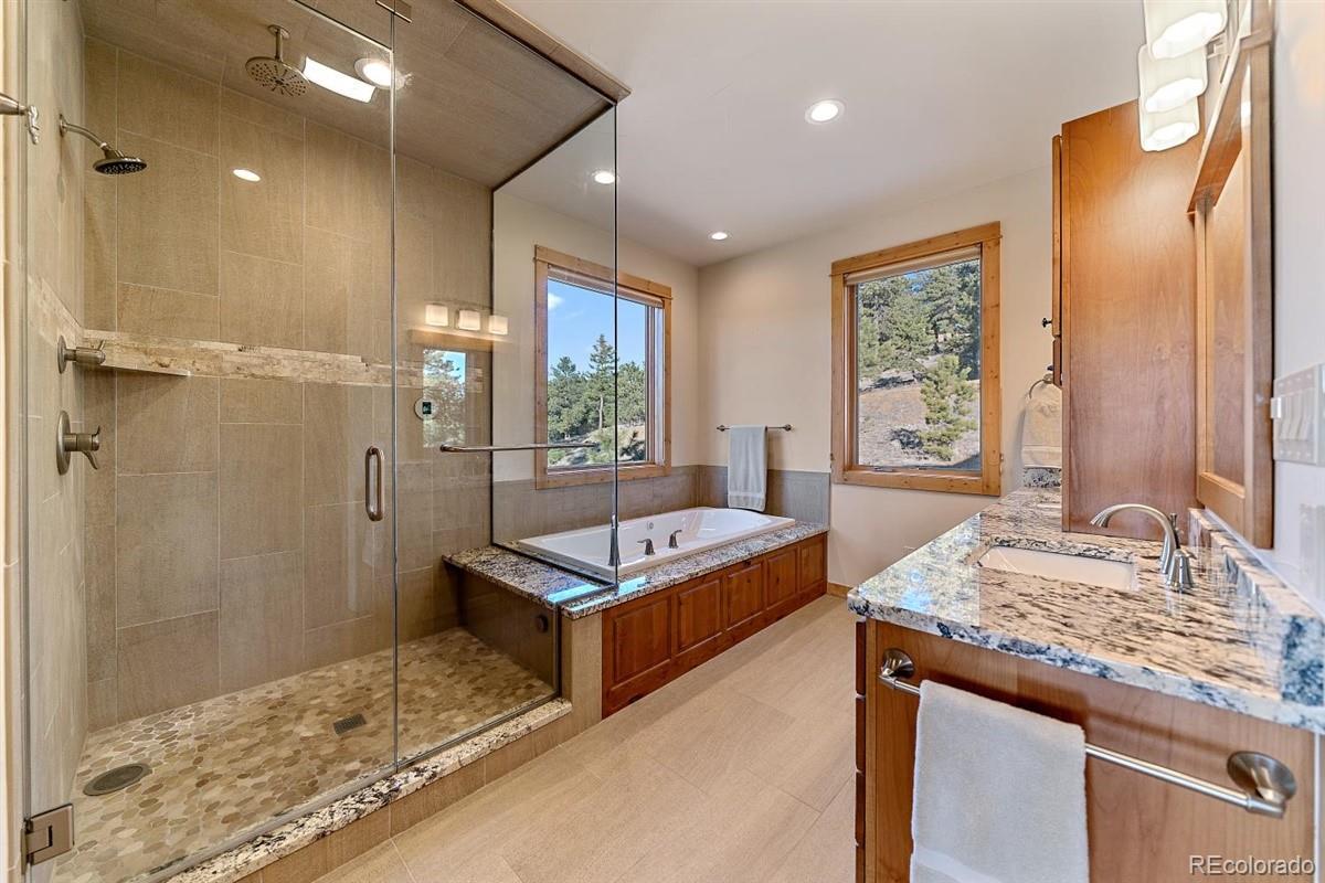 2848 Quartz Ridge Road Evergreen, CO 80439 - Photo 14 of 40 a spacious bathroom with a granite countertop sink and a mirror