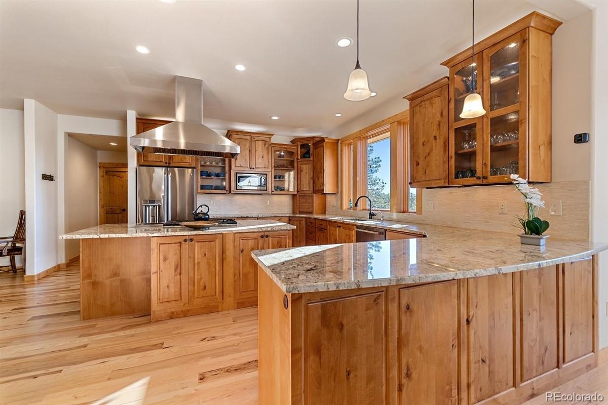 2848 Quartz Ridge Road Evergreen, CO 80439 - Photo 9 of 40 a kitchen with stainless steel appliances granite countertop a sink a stove and a wooden floors